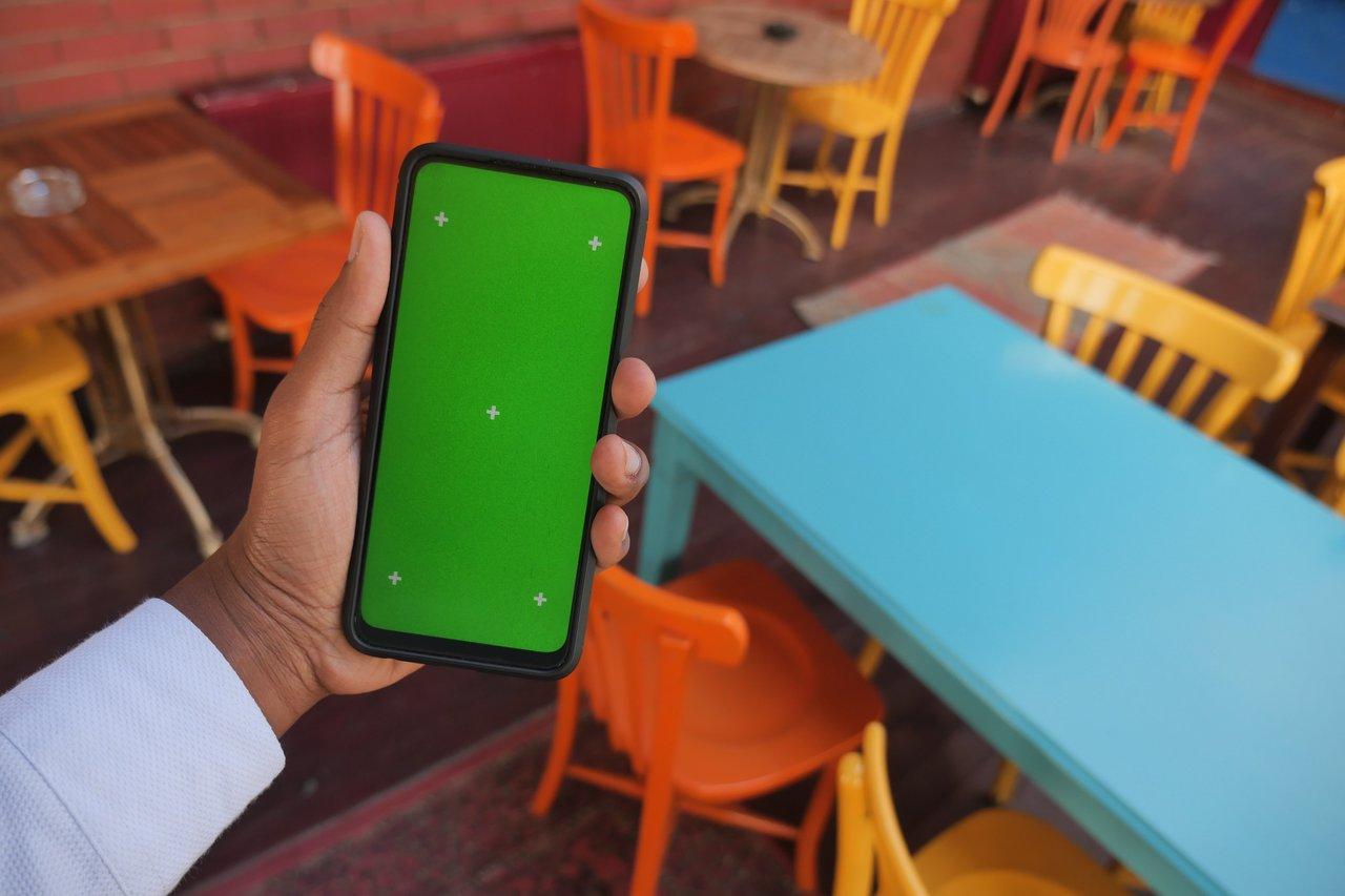 Création d'un filtre AR personnalisé avec Effect House, illustrée par une main tenant un smartphone en café.