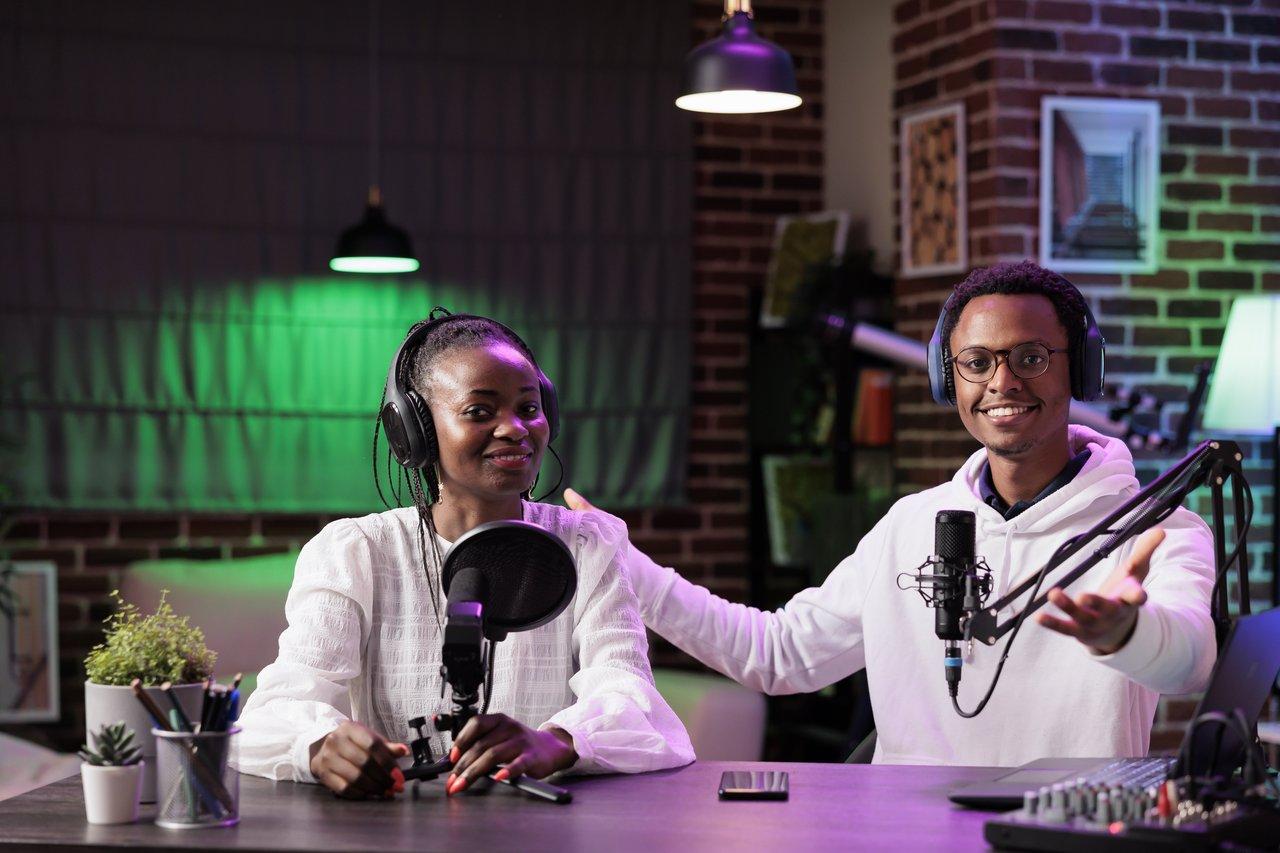 Deux créateurs YouTube collaboration studio enregistrent un défi en duo dans un espace lumineux avec équipement professionnel.