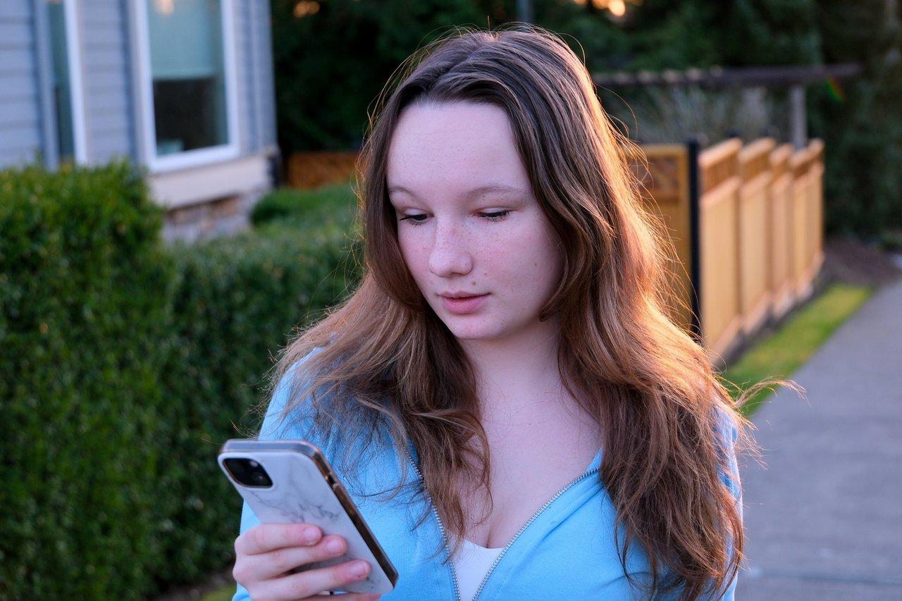 Un adolescent confronté à la pression sociale en ligne, illustrée par notifications de likes et commentaires.
