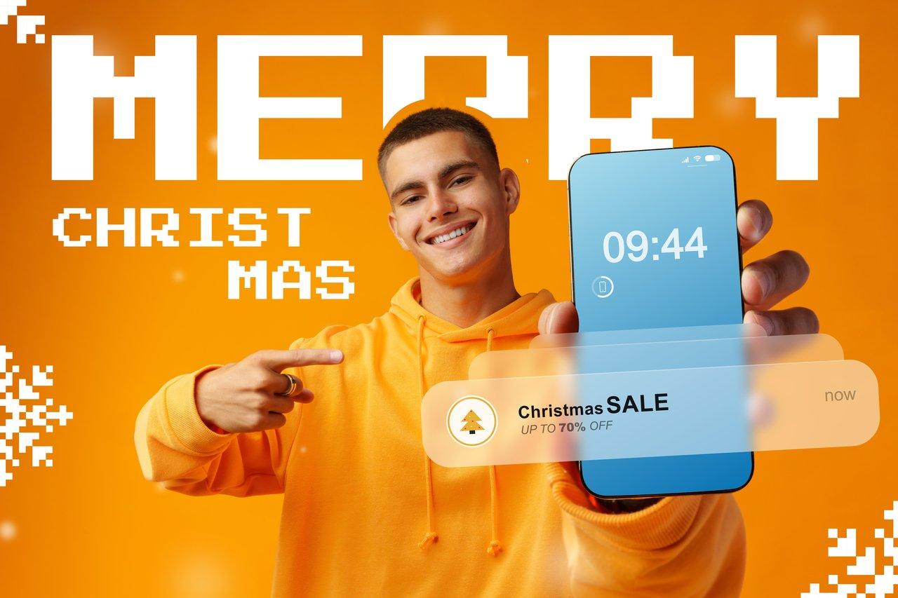 Un jeune homme joyeux découvre des promotions festives sur un calendrier de l'Avent digital.