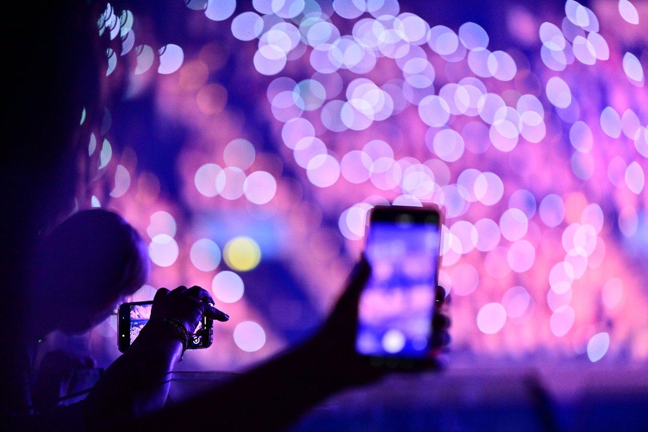 Une scène nocturne d'un festival digital avec une foule captivée par des animations interactives en extérieur.